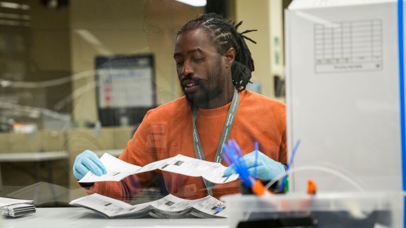Ballot opening lead Eldon Miller works at the King County Elections headquarters, Friday, Nov....