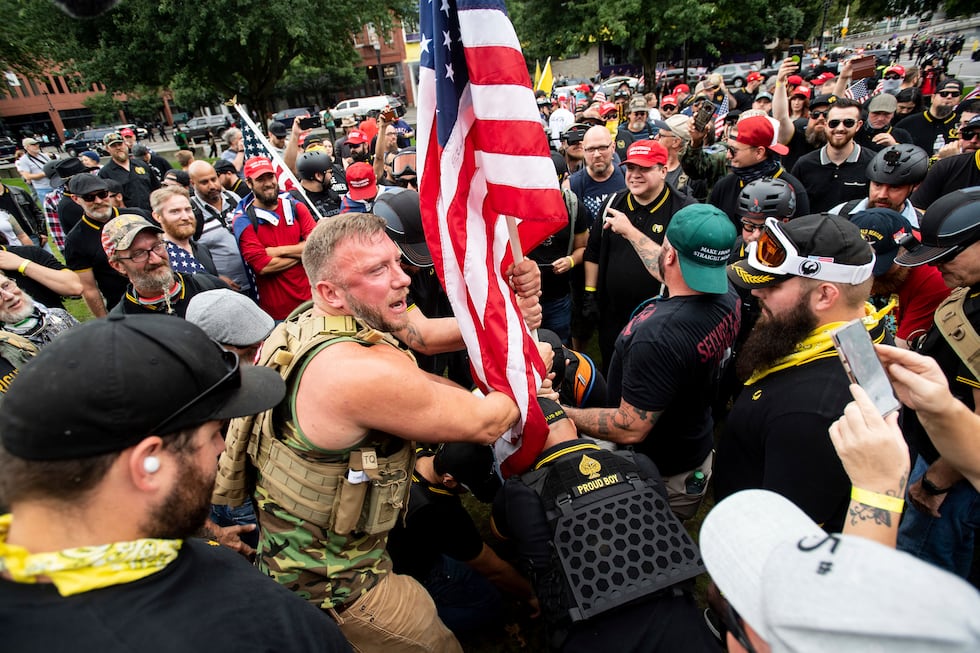Joseph Oakman and fellow Proud Boys plant a flag in Tom McCall Waterfront Park during an "End...