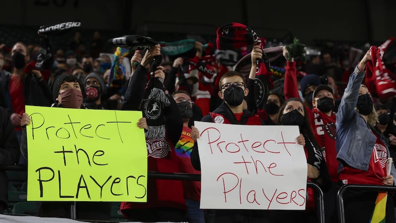 FILE - Portland Thorns fans hold signs during the first half of the team's NWSL soccer match...