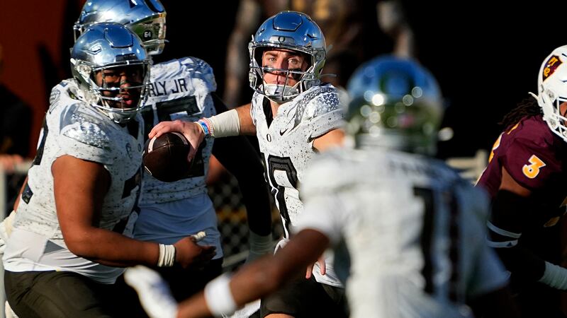 Oregon quarterback Bo Nix, center, looks to pass against Arizona State during the first half...