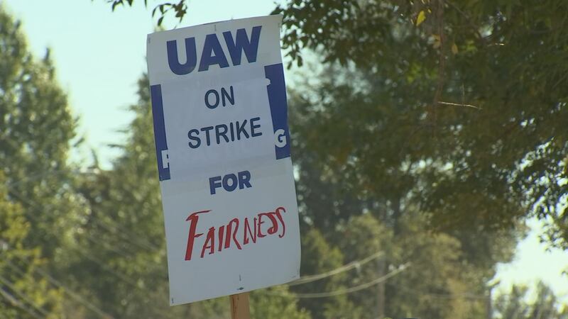 An auto union worker on strike holds a sign in Beaverton, Ore. on Friday, Sep. 22, 2023.