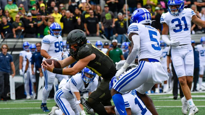 Oregon quarterback Bo Nix reaches across the goal line to score against BYU during the first...