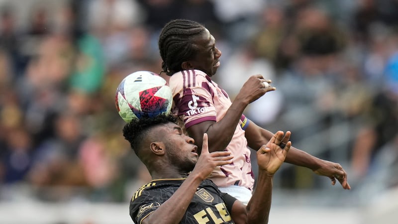 Los Angeles FC midfielder Jose Cifuentes, bottom, heads the ball against Portland Timbers...