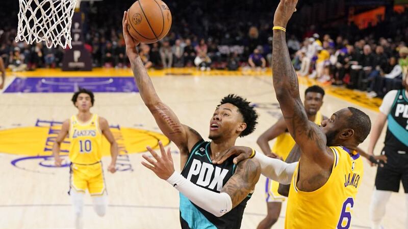 Portland Trail Blazers guard Anfernee Simons, second from left, shoots as Los Angeles Lakers...