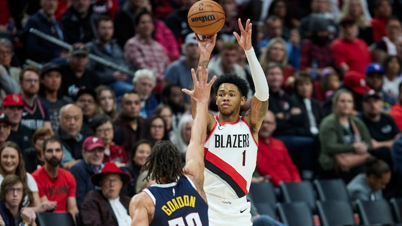 Portland Trail Blazers guard Anfernee Simons, right, shoots a 3-point basket over Denver...