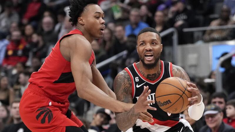 Portland Trail Blazers guard Damian Lillard, right, dribbles as Toronto Raptors forward...