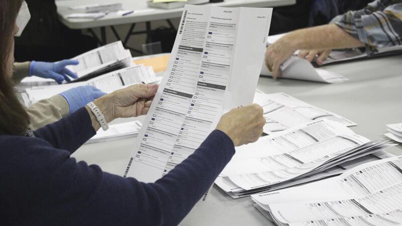 An election worker examines a ballot at the Clackamas County Elections office on May 19, 2022,...