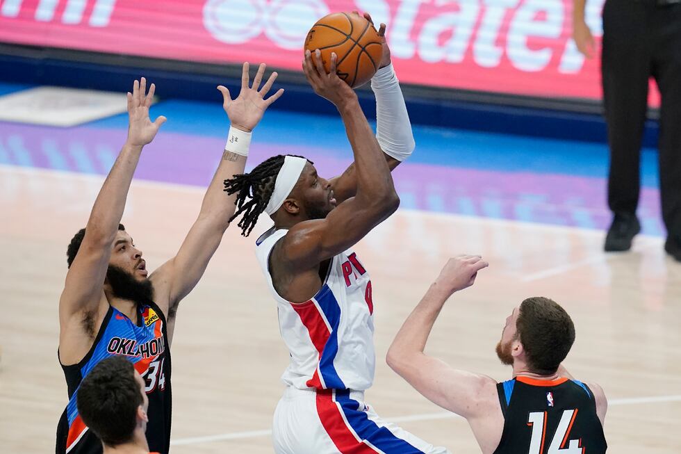 Detroit Pistons forward Jerami Grant, center, drives between Oklahoma City Thunder forward...