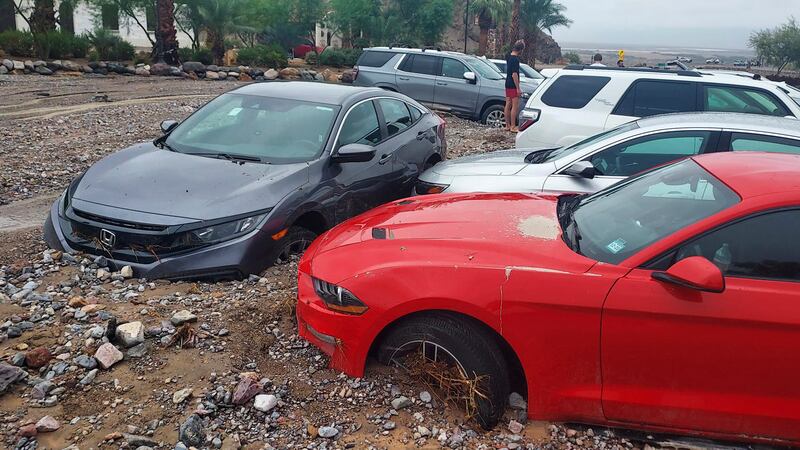 In this photo provided by the National Park Service, cars are stuck in mud and debris from...